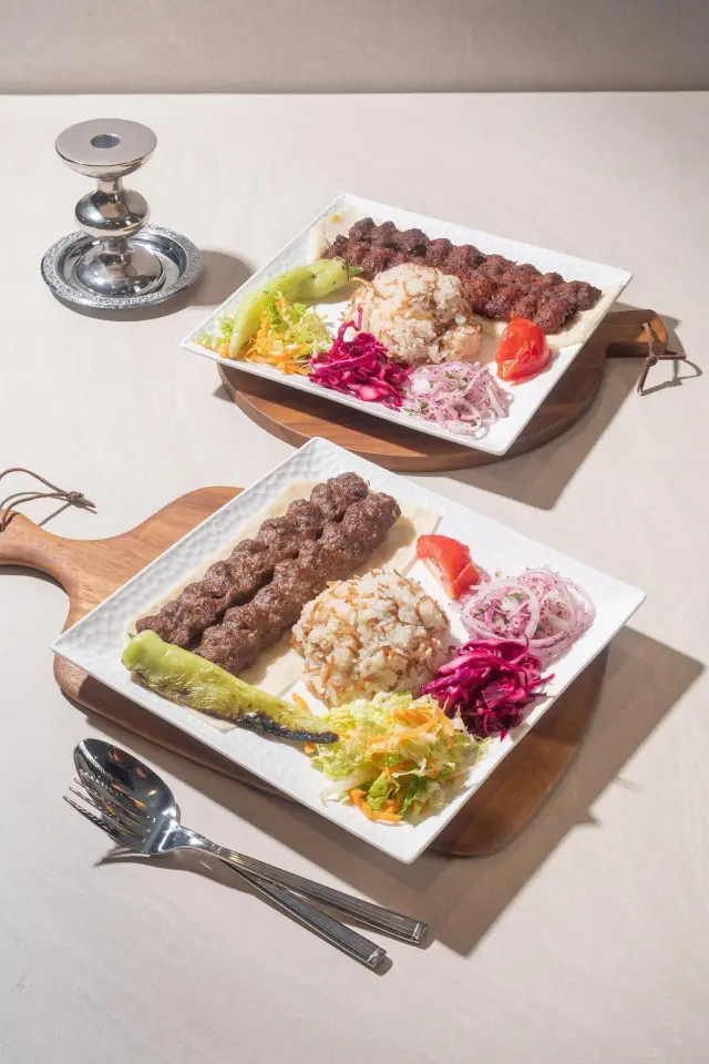 Adana and Urfa kebab skewers with grilled vegetables and rice