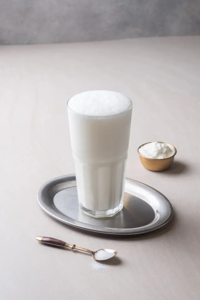 Cold foamy ayran yogurt drink in a copper cup