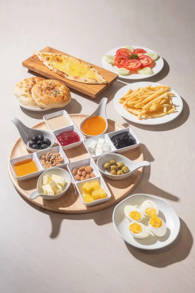 Rich Turkish breakfast spread for two with cheeses, pastries, eggs and pide