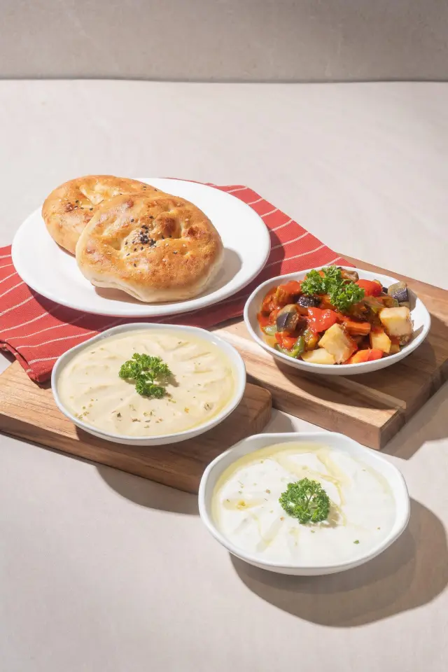 Shakshuka, hummus and haydari meze bowls with fresh bread