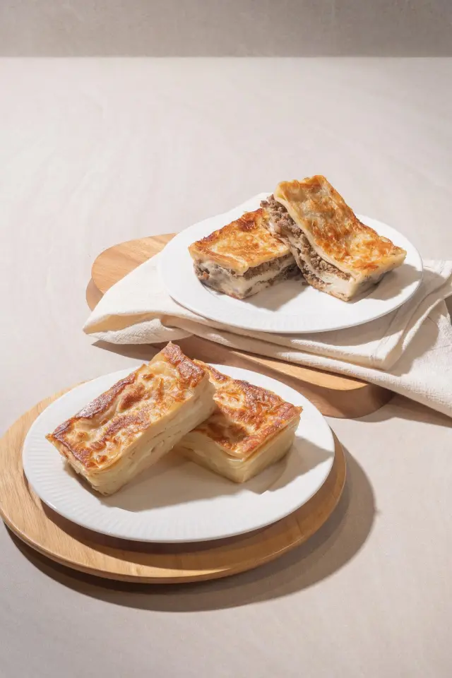 Golden baked su böreği pastries with meat and cheese fillings